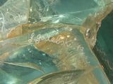 a close up of a broken glass object with writing on it