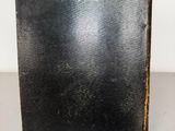an old book sitting on top of a table next to a white wall
