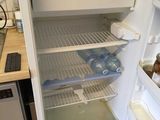 an open refrigerator in a small kitchen with the door open