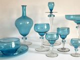 de nombreux objets en verre bleu posés sur une table