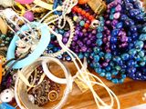 un tas de bijoux posé sur une table, à côté d'une paire de ciseaux