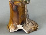 a figurine of a frog sitting on top of a tree stump