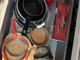 a drawer full of pots and pans and other kitchen items