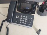 a telephone that is sitting on a desk next to a pen and pencil holder