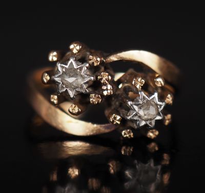 gros plan d'une bague en or et diamants sur une surface noire