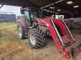 a red tractor that is parked in a barn