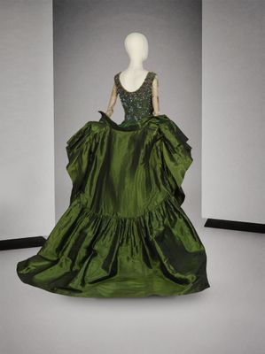 une photo d'un mannequin portant une robe verte dans une pièce