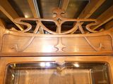 a wooden cabinet with a glass door and a mirror