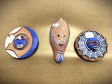 three decorative items that are sitting on a gold surface