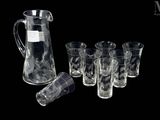 un pichet et six verres posés les uns à côté des autres