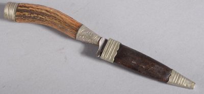 un couteau avec un manche en bois sur une surface blanche
