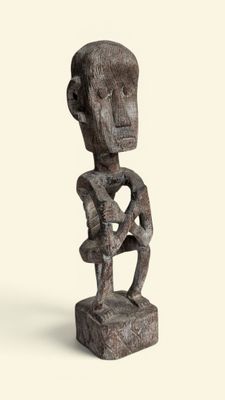 une image représentant une sculpture en bois d'un homme tenant un bébé dans ses bras