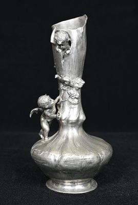 un vase en argent sur lequel est représenté un petit garçon