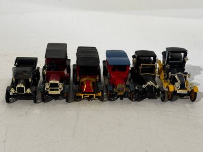 several toy cars are lined up in a row on a white surface