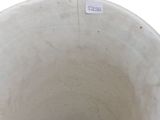 a white vase that has a sticker on the side of it