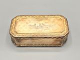an antique silver box with a lid on a gray surface