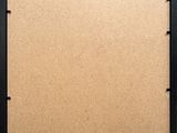 a close up of a cork board with a black frame and screws