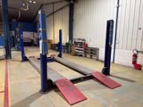 a picture of a garage with two lifts in it