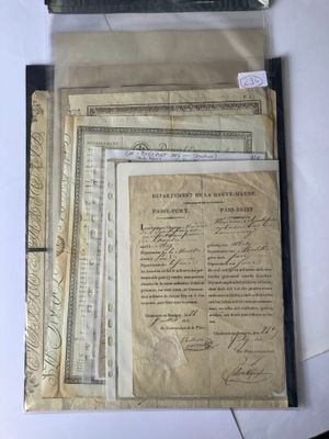an old document is sitting on top of a table next to a stack of old papers