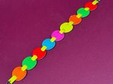 a colorful bracelet made out of plastic beads on a purple surface