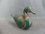 a green and brown duck figurine sitting on a table