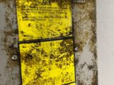 a metal box with a yellow sign attached to it