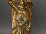 brass statue of a woman holding a bird and a basket on her head