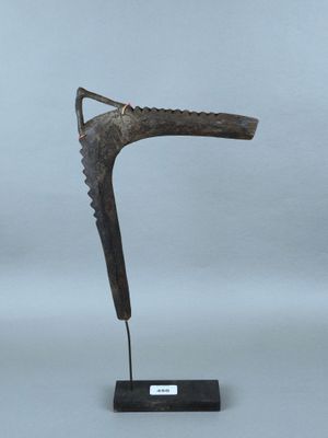 une sculpture en bronze représentant une chaussure posée sur un socle noir