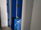 three blue lockers in a room with tile flooring