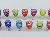many different colored glasses sitting on a white surface