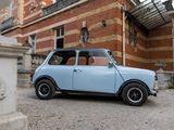 a small blue car parked in front of a brick building
