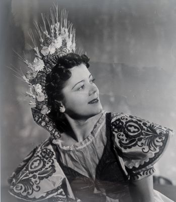 une vieille photo en noir et blanc représentant une femme vêtue d'une robe et portant une couronne