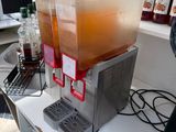 two juice dispensers sitting on a counter in the kitchen