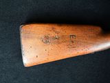 a close up of a wooden rifle on a black surface