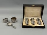 three silver cups and spoons in a box on a table