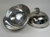 silver plate with a bird on it and a silver bowl with a lid