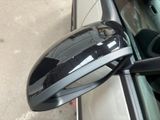a side view mirror of a car on the side of the road