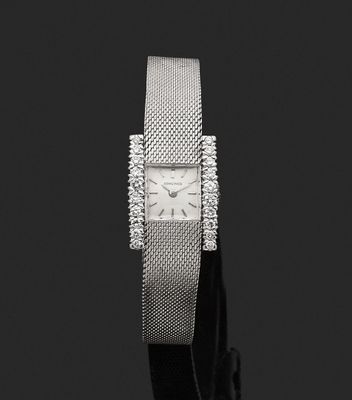 a close up of a watch on a black surface with a black background