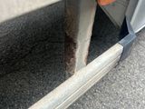 a close up of a car ' s bumper with a rusted tire