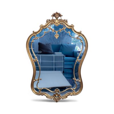 une image représentant un miroir doré avec un canapé bleu en arrière-plan