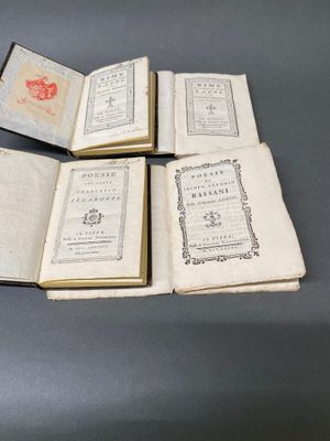 trois livres ouverts posés sur une table l'un à côté de l'autre