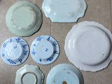 many plates and bowls sitting on the floor next to each other