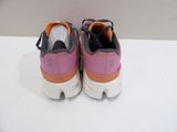 pink and orange sneakers with black laces on a white surface