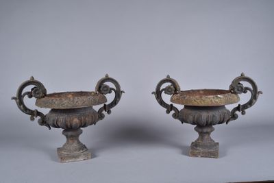 pair of antique bronze urns on pedestals on white background