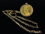 a close up of a gold coin with chains on a black background