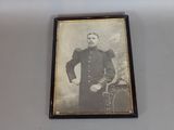 an old photo of a man in a military uniform is hanging on a wall