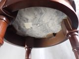 a close up of a wooden chair with a marble ball on it