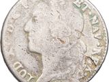 gros plan d'une pièce de monnaie sur laquelle figure une tête de femme