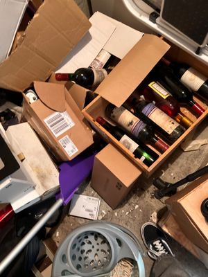 un tas de bouteilles de vin et d'autres objets par terre