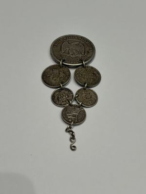 a close up of a necklace with coins hanging from it